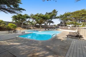 una piscina con sillas y árboles en un patio en Monterey Dune Haven, en Moss Landing