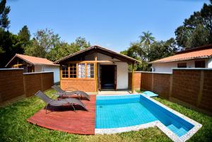 un patio trasero con piscina y una casa en Chalés da Estrada Velha, en Tiradentes