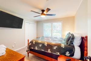 une chambre avec un lit et un ventilateur de plafond dans l'établissement High Country Cottage, à Newland