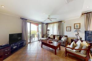 a living room with a couch and a tv at Bougainvillea 2101 in Playa Conchal
