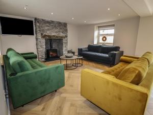 a living room with two couches and a fireplace at Rhos Las in Derwen