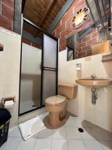 a bathroom with a toilet and a sink at Hotel Parador del Gitano in Doradal