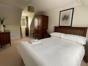 a bedroom with a large white bed with white sheets at Bracken Cottage in Killean