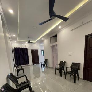 a room with chairs and a ceiling fan at Abode Homestay Alleppey Near Omanapuzha Beach in Alleppey
