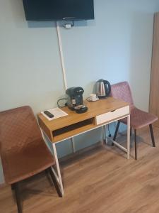 un escritorio con 2 sillas y un hervidor de agua. en U Józefa, en Tychy