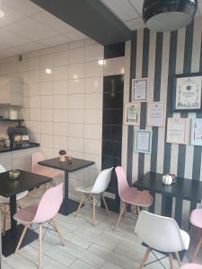 un restaurante con mesas y sillas rosas en una habitación en U Józefa, en Tychy