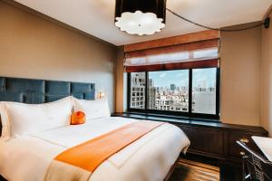 a bedroom with a large bed and a window at Soho Grand Hotel in New York