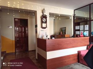 a bar in a restaurant with a clock on the wall at Hotel Kurtabeg in Shkodër