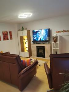 a living room with two couches and a flat screen tv at Quitte10 in Glindow