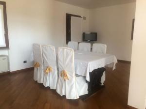eine Gruppe weißer Stühle um einen Tisch in der Unterkunft Antico Borgo di Liteggio in Cologno al Serio