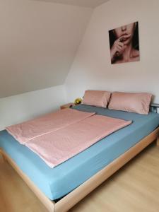 Bett in einem Zimmer mit einem Bild an der Wand in der Unterkunft Quitte10 in Glindow