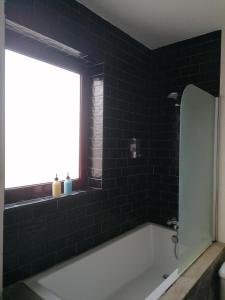 a bathroom with a bath tub and a window at Casa da Canada da Fajã in Feteira +27 photos