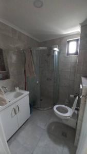 een badkamer met een douche, een toilet en een wastafel bij Saray park in Alanya