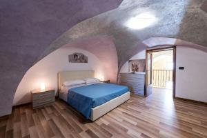 Magliano的住宿－La casa di nonno Mario, Salento，拱形天花板上的卧室配有一张床