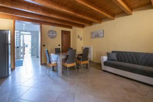 - un salon avec une table, des chaises et un canapé dans l'établissement La casa di nonno Mario, Salento, à Magliano