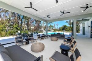 eine Terrasse mit Sofas und Stühlen sowie einem Pool in der Unterkunft A Luxurious Getaway Key Location in Orlando