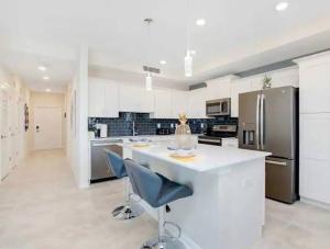 eine Küche mit einer weißen Theke und einem Kühlschrank in der Unterkunft A Luxurious Getaway Key Location in Orlando