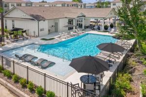 einen Pool mit Stühlen und Sonnenschirmen in der Unterkunft A Luxurious Getaway Key Location in Orlando