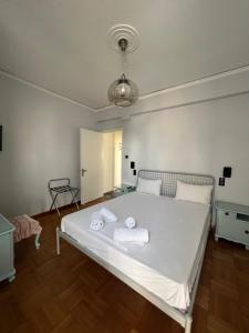 1 dormitorio con 1 cama blanca y 2 toallas en Happy Place! Big, Bright & Central - Ideal for families and groups of friends, en Patra