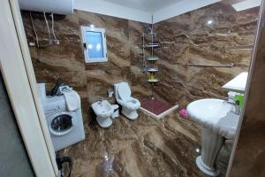 e bagno con lavandino, servizi igienici e doccia. di villa Heljos apartaments a Vlorë
