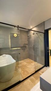 een badkamer met een glazen douche en een wastafel bij Sandi Hotel in Paraty
