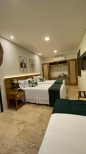 um quarto de hotel com duas camas num quarto em Sandi Hotel em Paraty