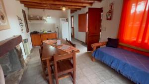 um quarto com uma mesa e uma cama e uma cozinha em Complejo Sol Serrano em Mina Clavero