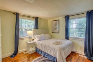 a bedroom with a bed and two windows at Mid-Century Wilmington Cottage 3 Mi to Riverwalk in Wilmington