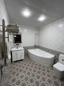 y baño con bañera, aseo y lavamanos. en Usman, en Samarkand