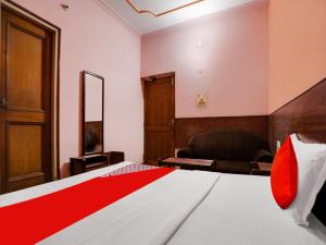 a bedroom with a bed and a chair in a room at OYO Flagship Jaiswal Star Stay in Lucknow
