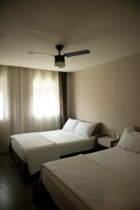 Habitación de hotel con 2 camas y ventilador de techo. en Hotel Internacional, en Comitán de Domínguez