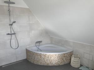 a bath tub in a bathroom with a shower at Ferienwohnung kleines Glück in Lübeck