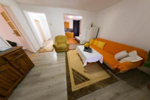 uma sala de estar com um sofá laranja e uma mesa em Apartman Bucko em Bihać