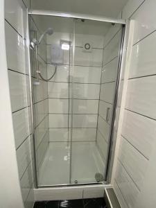 um chuveiro com uma porta de vidro na casa de banho em Oak Lodge em Welling