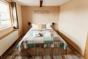 ein Schlafzimmer mit einem Bett mit einer Decke darauf in der Unterkunft Waldrandzauber in Benneckenstein