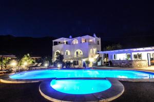 a large swimming pool in front of a house at night at Villa Anna Maria in Mylopotas