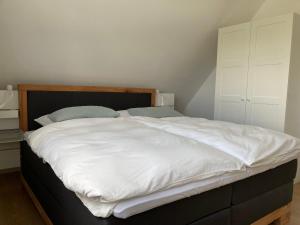 a bedroom with a large bed with white sheets at Ferienwohnung kleines Glück in Lübeck