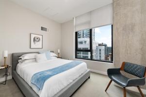ein Schlafzimmer mit einem Bett, einem Stuhl und einem Fenster in der Unterkunft Xl apartments at the GoldCoast- Cloud9-833 in Chicago