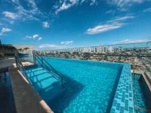 una piscina en la parte superior de un edificio con ciudad en Luxuoso Apto 2Q Jd Goiás - 1103T en Goiânia