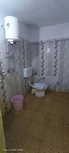 a bathroom with a toilet and a water tank at Kedarnath Tent Prithvi yatra Hotel in Kedārnāth