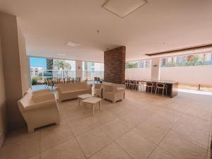 a living room with couches and a table and chairs at Luxuoso Apto 2Q Jd Goiás - 1103T in Goiânia