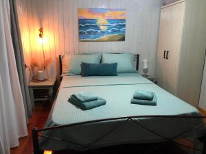 a bedroom with a large bed with blue pillows on it at Cozy Home Kanali, Preveza in Kanali