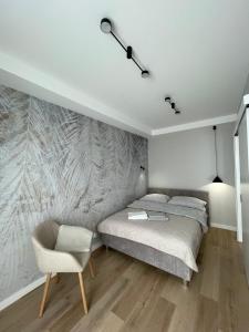 a bedroom with a bed and a chair at Apartament na Górnej in Kielce