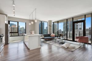 Cet appartement comprend un salon doté de grandes fenêtres. dans l'établissement Xl apartments at the GoldCoast- Cloud9-833, à Chicago