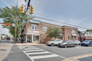 an intersection with cars parked in front of a brick building at Hatboro Retreat Steps From Shopping and Dining! 