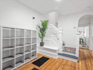 une chambre avec des étagères blanches et une plante en pot dans l'établissement Oakland/University @E Stylish and Central Private Bedroom with Shared Bathroom, à Pittsburgh