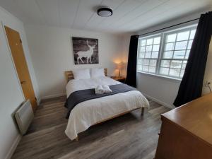 a bedroom with a bed and a window at Aux 4 vents - Auberg'Inn in Carleton-sur-Mer