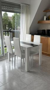 una mesa blanca y sillas blancas en la cocina en Picsine, Tennis résidence sévigné 300m mer, en Deauville