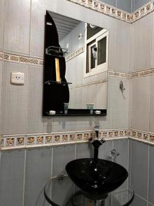 W łazience znajduje się szklana umywalka i lustro. w obiekcie ركن فينيسيا للشقق المخدومة w mieście Ha'il