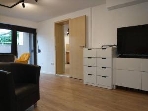 a living room with a flat screen tv and a dresser at Schicke hundefreundliche Wohnung in Alsheim